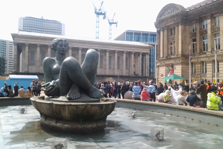 Image of Victoria Square Birmingham with protesters in background