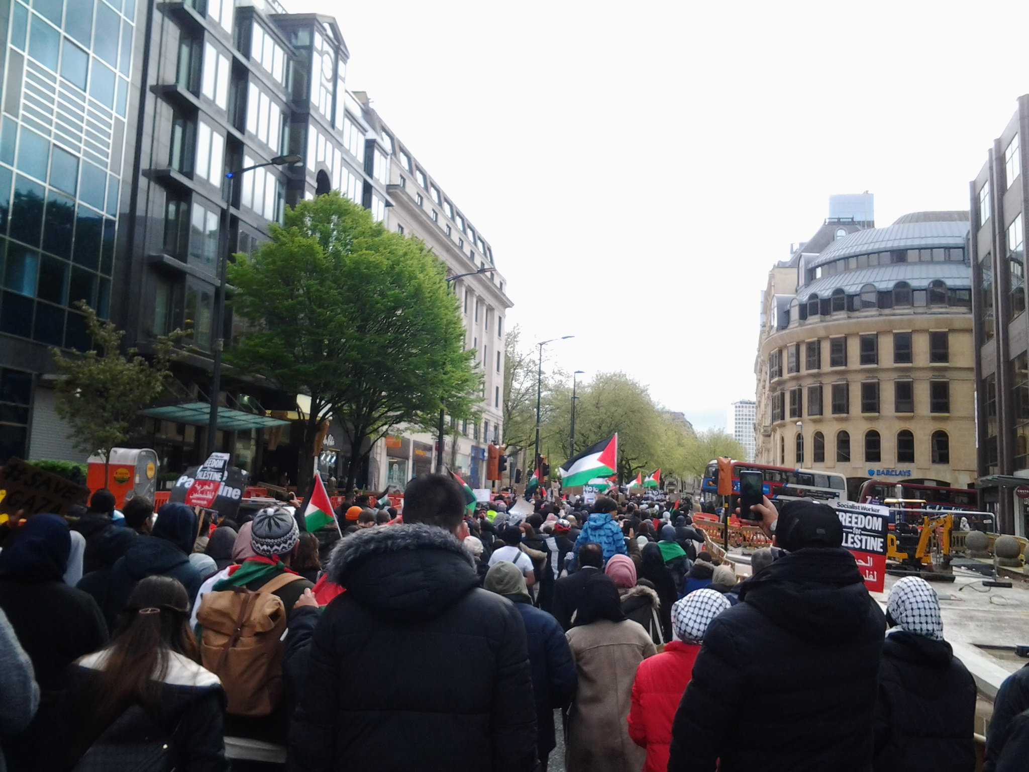 Protesters marching with Palestine flags near Colmore Row, Birmingham