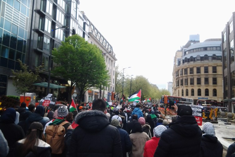 Protesters marching with Palestine flags near Colmore Row, Birmingham