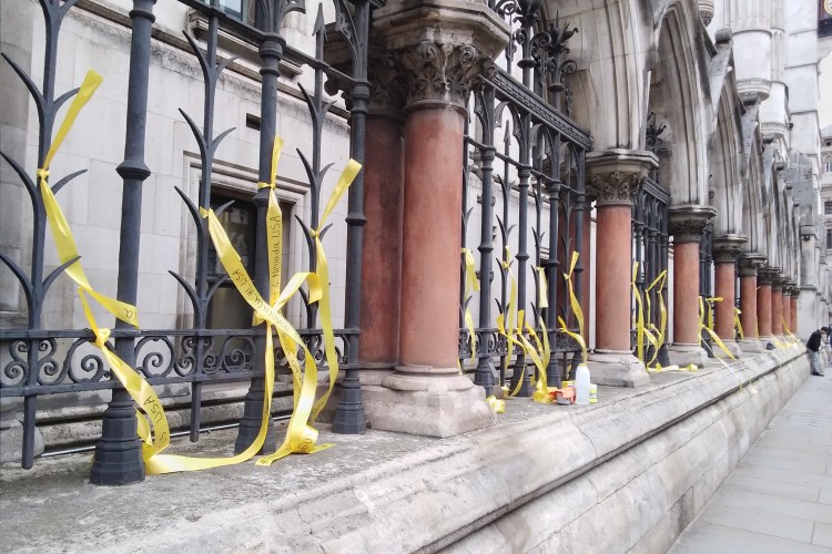 Yellow ribbons tied to bars near Royal Courts of Justice, Aldwych, London.