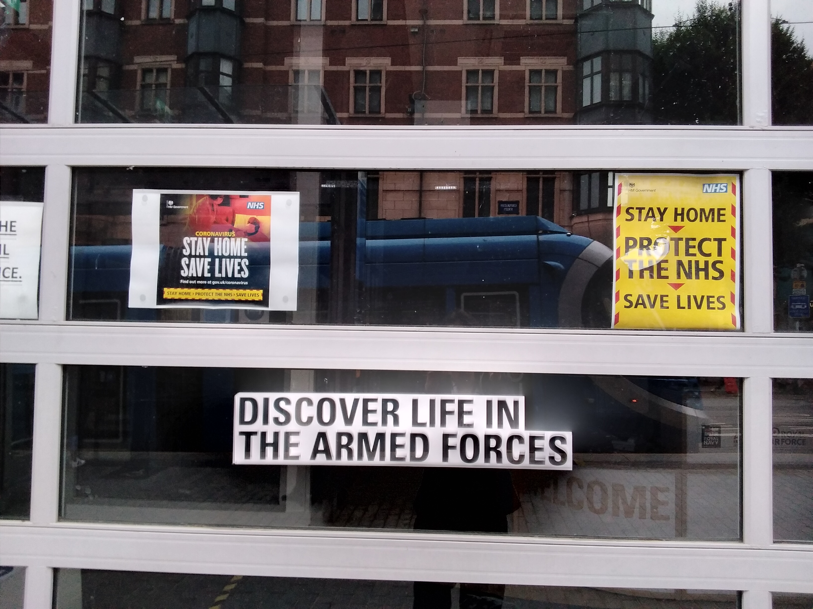 Army recruitment hub. Window reads "Discover Life in the Armed Forces". Tacked sign above it reads "Stay Home, Save Lives"