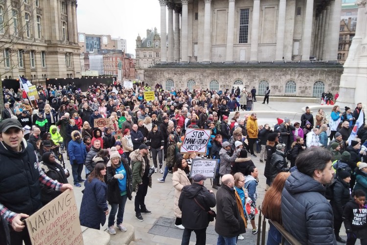 Large number of protesters, sign in front says No Mandatory vaccines.