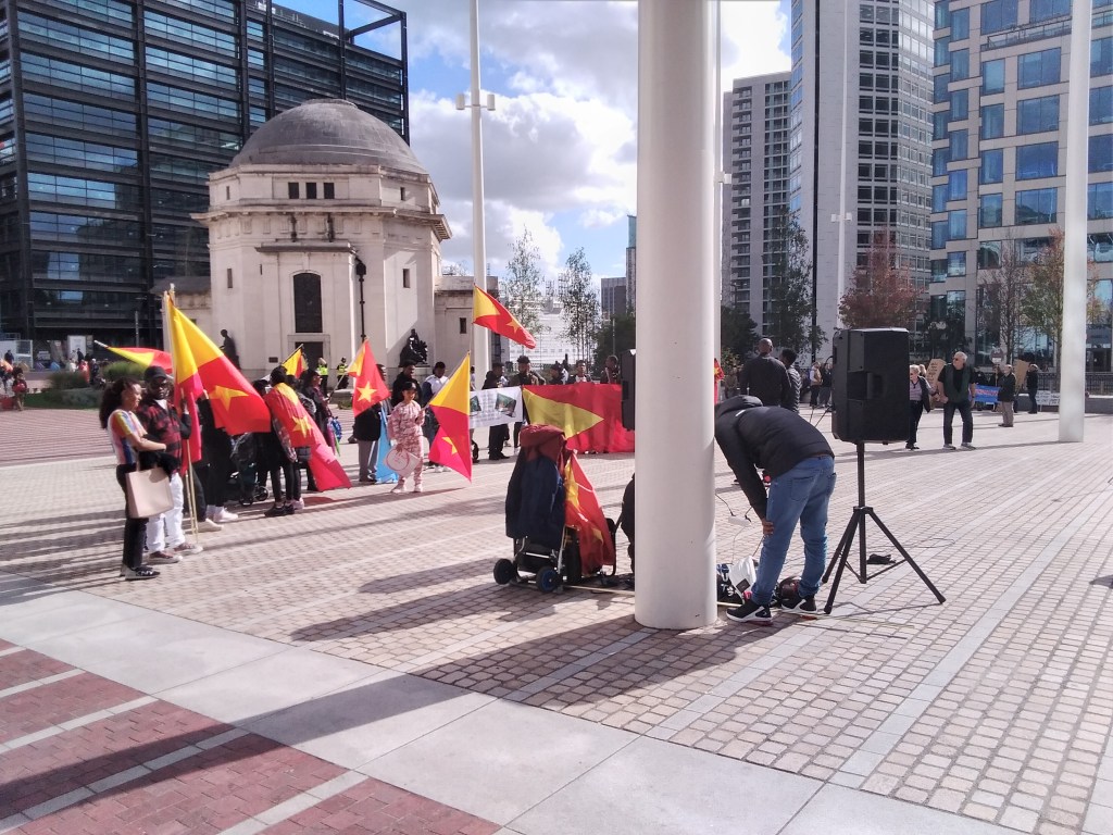 Protesters holding yellow and red flags.