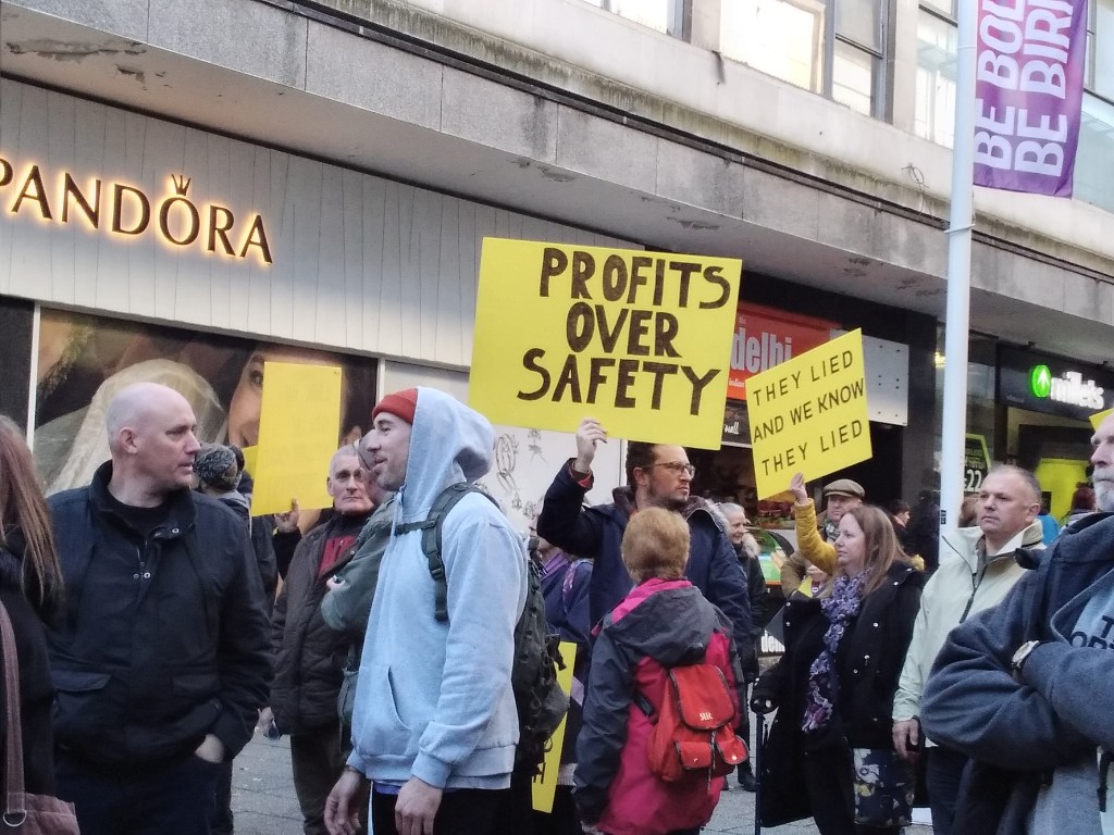 Signs reading "Profit over Safety" "they lied and we know they lied"