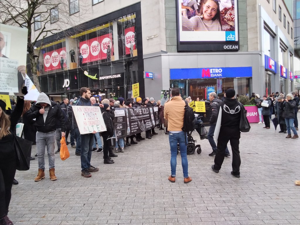 Crowd of protesters in city centre outside JD sports shop