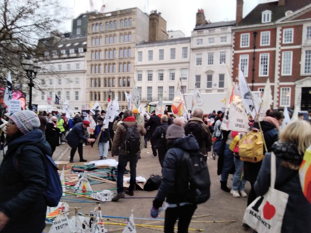 Crowd milling about holding lanterns